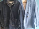 deux vestes accrochées à une porte bleue devant une porte bleue