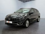 Une voiture noire est garée dans une grande pièce aux murs blancs