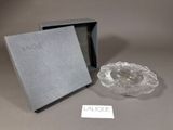 un cendrier en verre et une boîte posés sur une table