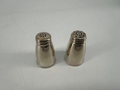 pair of silver salt and pepper shakers on a white surface