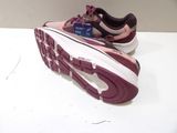 purple and white running shoe on a table with a credit card