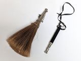 a close up of a pair of scissors and a hairbrush on a white surface