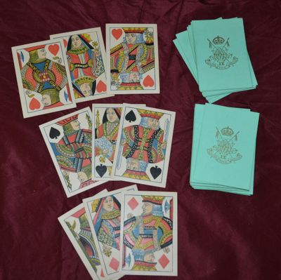 Plusieurs cartes à jouer sont disposées sur un lit recouvert de feuilles de papier