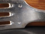 a close up of a metal fork with holes in it