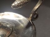 a silver plate with a snake on top of it