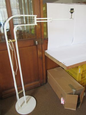 une lampe blanche posée sur un pied à côté d'une boîte