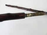 a knife that is laying on top of a wooden stick