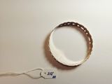 a white bracelet with a tag on it on a table