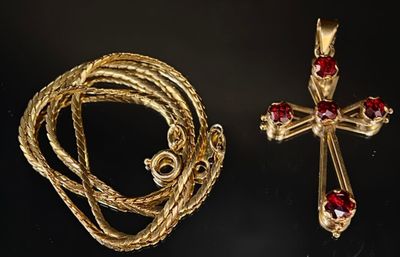 un gros plan sur un collier et une croix posés sur une table