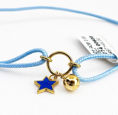 bracelet avec une breloque en forme d'étoile et une clochette, monté sur un cordon bleu