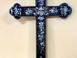 blue and white cross with floral design on it on a wall