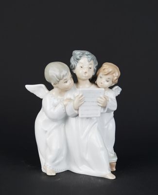 trois figurines d'anges tenant une feuille de papier sur fond noir