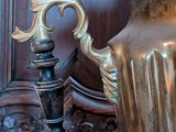 a large silver vase sitting on a table next to a candle