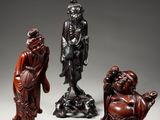 a group of four carved wood figures of buddhas