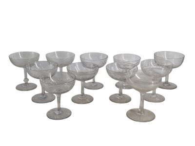 six verres à vin transparents sont alignés sur une surface blanche