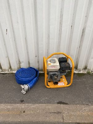 a yellow fire hydrant and a blue hose on the side of the street