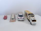 trois petites voitures et un petit camion posés sur une table