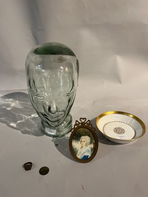 un vase en verre orné de l'image d'une femme, à côté d'un petit bol