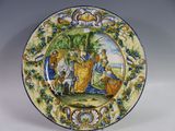 une assiette décorative ornée d'une peinture, posée sur une table
