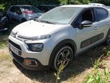 une petite voiture blanche garée dans l'herbe à côté d'autres voitures