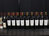 Des bouteilles de vin sont alignées sur une table devant un fond noir.