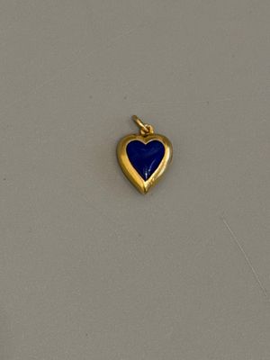 une photo d'un pendentif en or en forme de cœur, orné d'une pierre de lapis-lazuli au centre