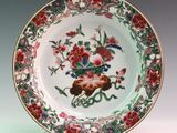 a plate with a bird and flowers on it