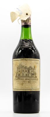 une vieille bouteille de vin posée sur une table blanche
