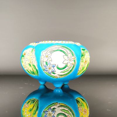 a blue vase with a green and yellow design on it