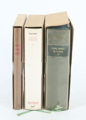 trois livres sont empilés sur une surface blanche
