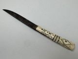 a close up of a knife on a table with a white background