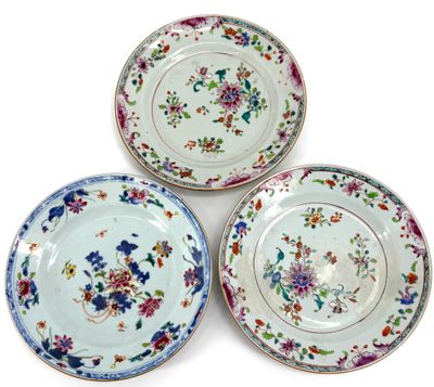 three plates with floral designs on them on a white surface