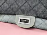 the back of a quilted purse with a button on it