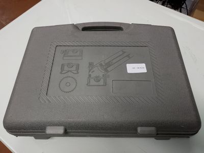 un étui noir posé sur une table, sur lequel est collé un autocollant