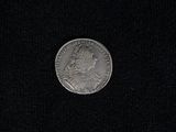 a close up of a silver coin on a black surface