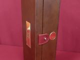 a brown box with a red handle on a pink surface