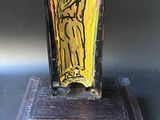 painting of a man in a yellow robe on a wooden stand