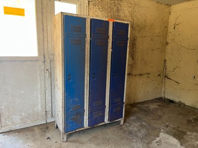 un casier bleu dans un coin d'une pièce sale