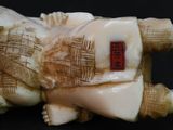 chinese carved ivory figurine of a man lying on his back