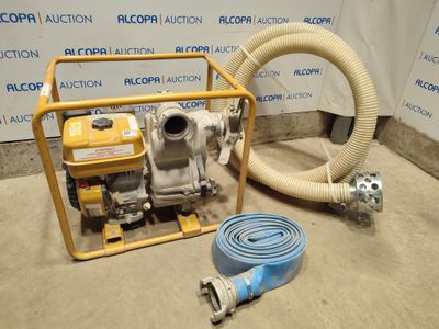a hose and a pump on the ground next to a wall