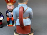 three figurines of a man in a crown and a man in a suit