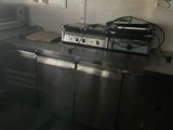 dimly lit kitchen area with stainless steel appliances and counter tops