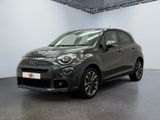 a grey fiat car parked in a large room with a white wall