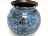 a blue vase that is sitting on a white surface