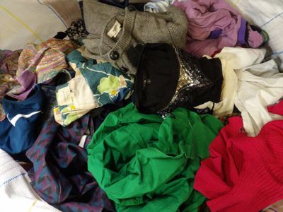 a pile of clothes that is on a bed