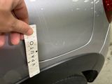 a person holding a piece of paper on the back of a car