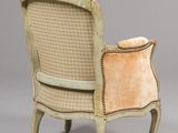 an old chair with a beige upholstered back and a tan upholstered seat