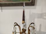 a glass candle holder on a table with a painting in the background