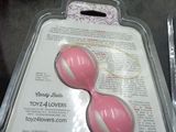 two pink balls in a plastic container on a table