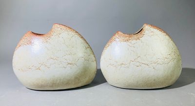 deux vases blancs posés l'un à côté de l'autre sur une table